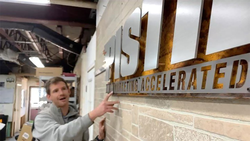 ShieldCo employee showing off custom sign