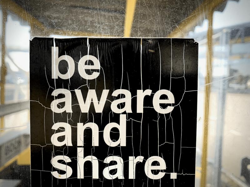 a custom outdoor sign that reads be aware and share